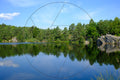 Waldsee und Granitfelsen unter blauem Himmel