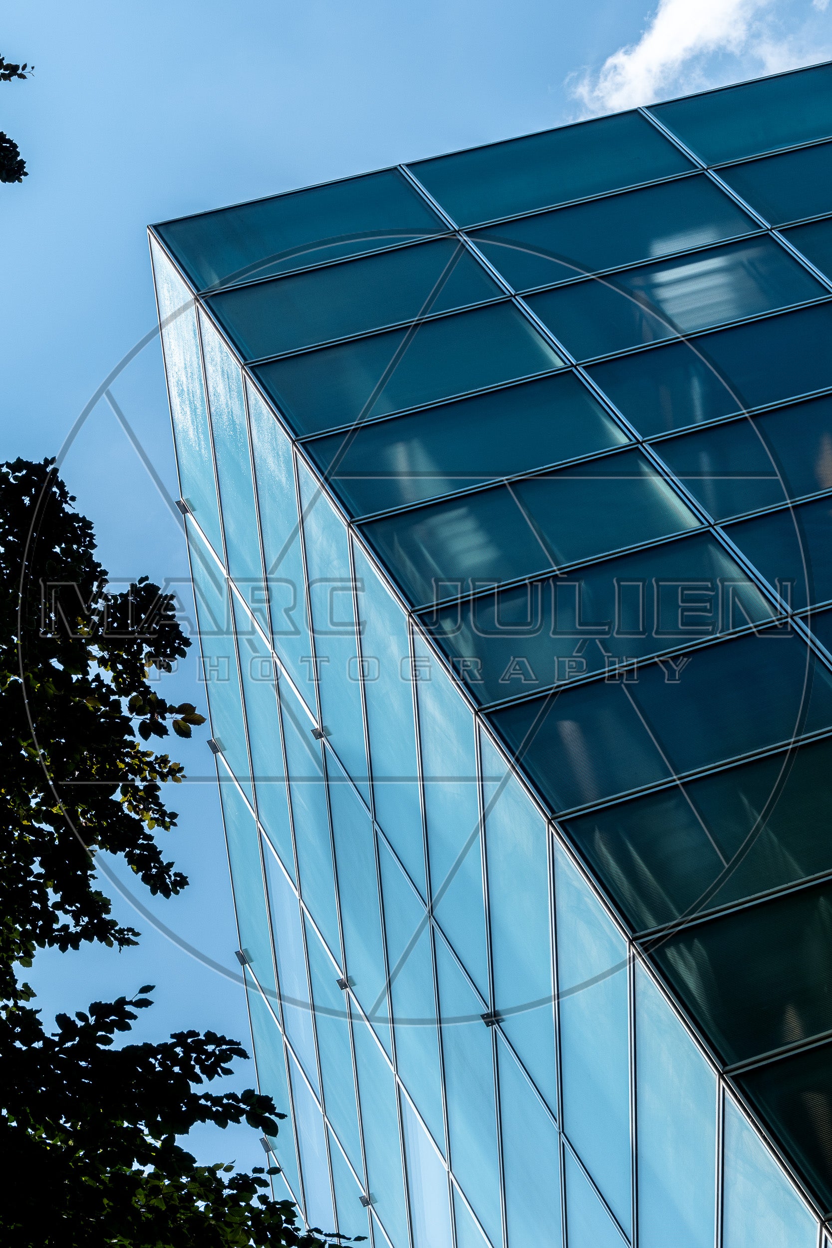 Façade vitrée contemporaine aux lignes géométriques sous un ciel bleu