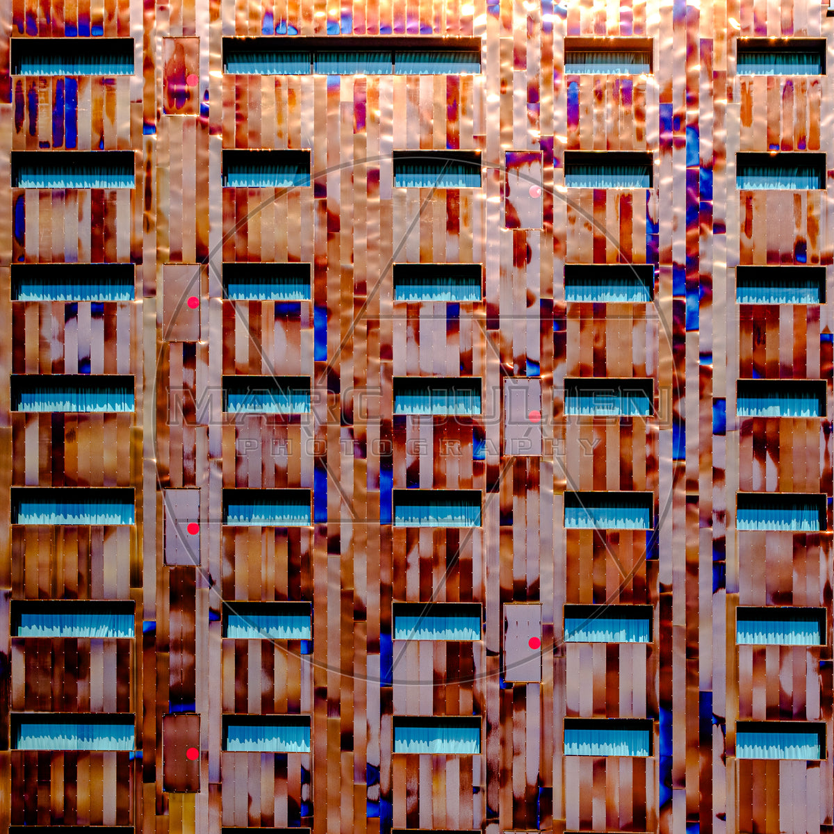 Façade contemporaine en métal aux couleurs cuivrées et fenêtres bleues
