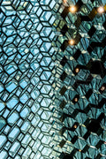 Architecture intérieure en verre aux motifs hexagonaux et reflets géométriques