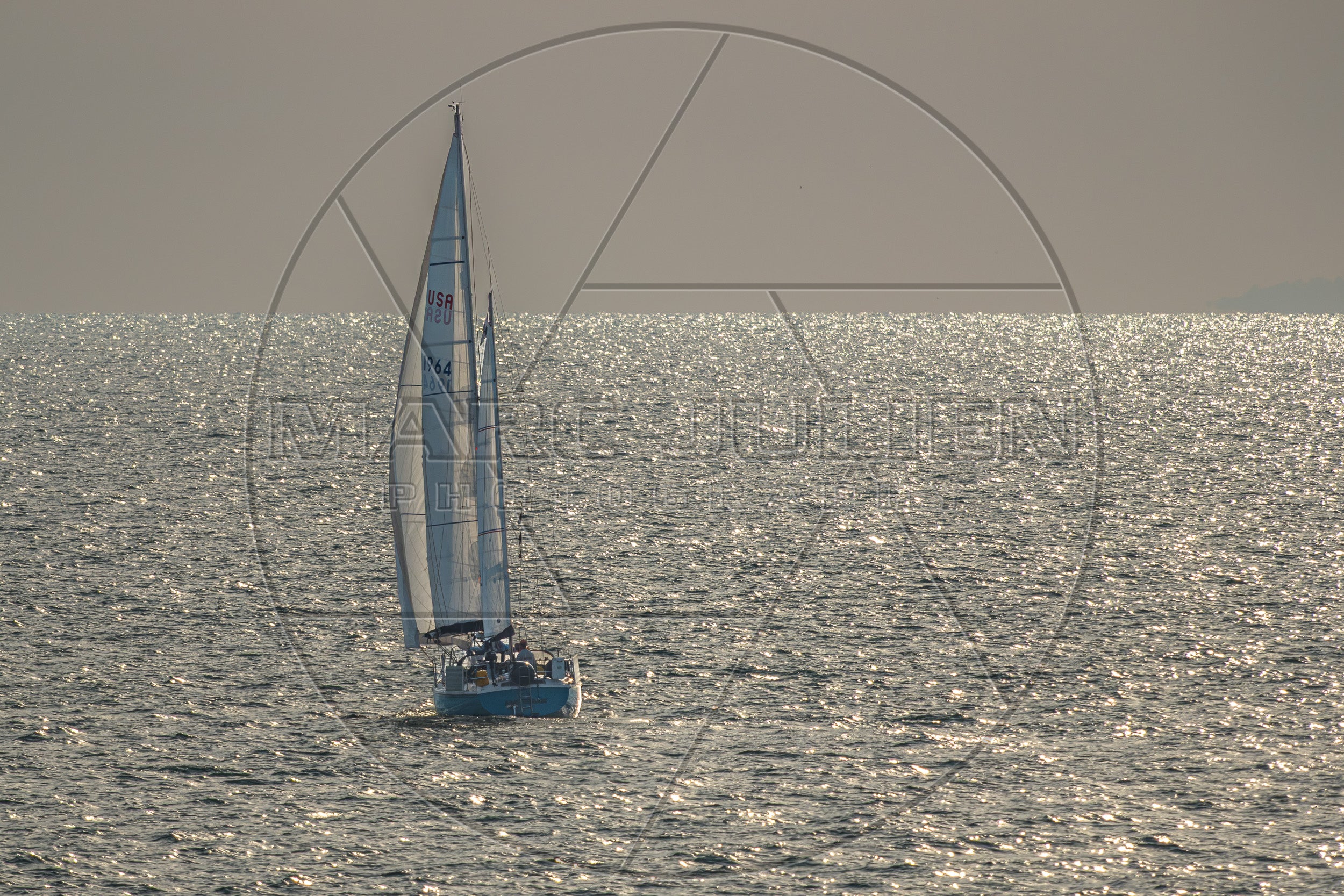 Segelboot auf glitzerndem Meer bei Sonnenuntergang