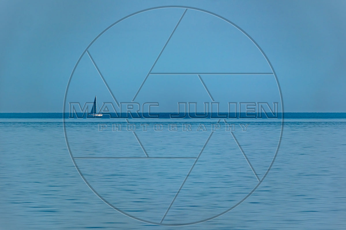 Ein einsames Segelboot am Horizont auf ruhiger See